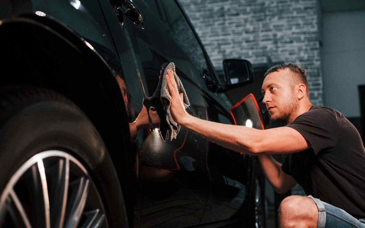 Auto detailing technician performing professional paint correction and ceramic coating preparation at Raven Auto Detailing in Allen, Texas.
